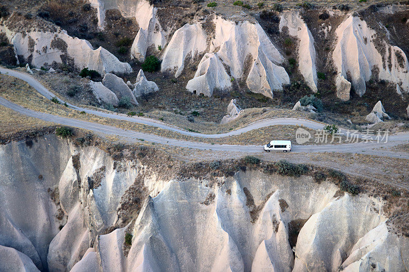 Mini van moving on part of Cappadocia road. Aerial view of scenic touristic route in Turkey with name Cappadocia Road.